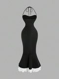 Back view of black halter mermaid midi dress with white layered ruffle hem