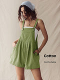 Front three-quarter view of olive pinstriped overall romper with hands in side pockets