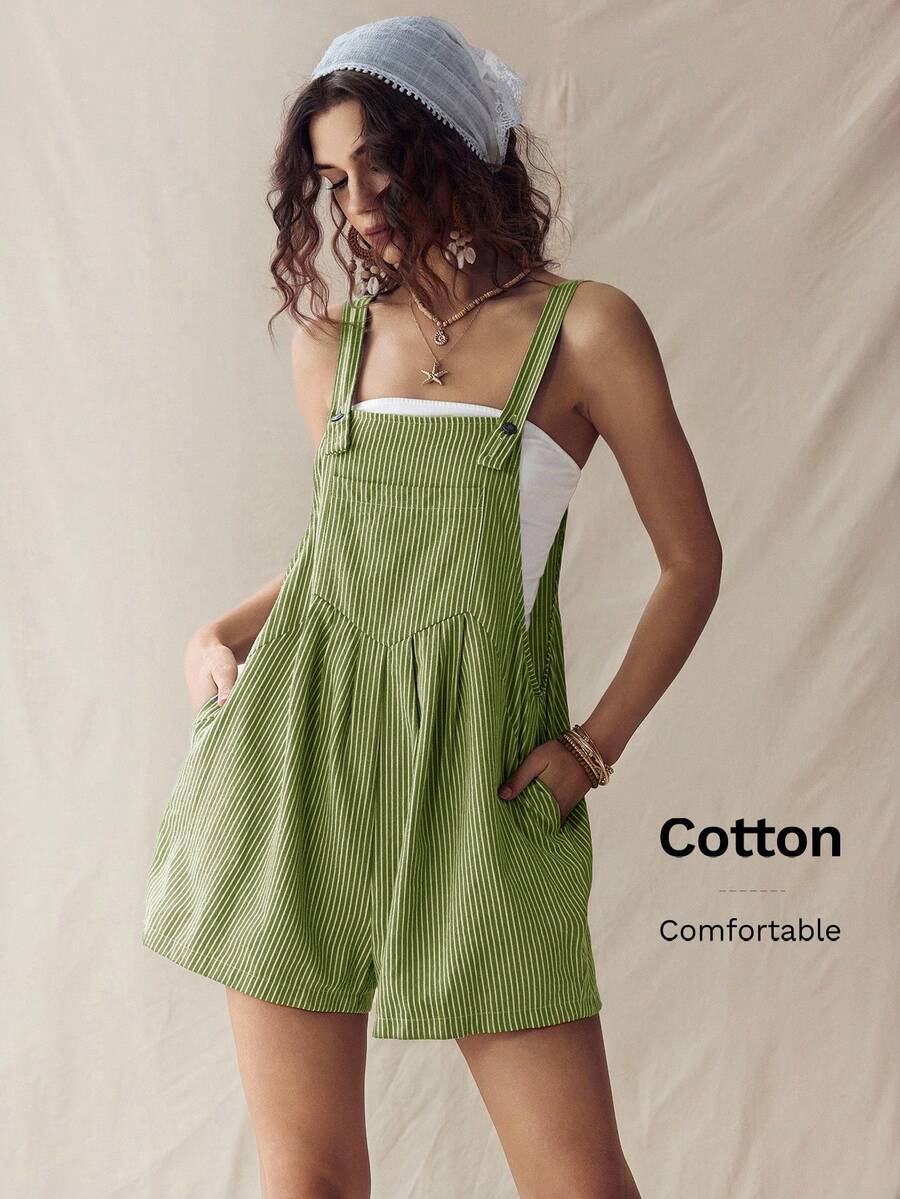 Front three-quarter view of olive pinstriped overall romper with hands in side pockets