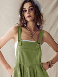 Close front view of olive pinstriped romper with buttoned straps and gathered waist seam