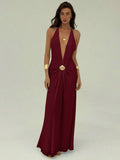 Front view of burgundy halter maxi dress with ruched waist and shell brooch