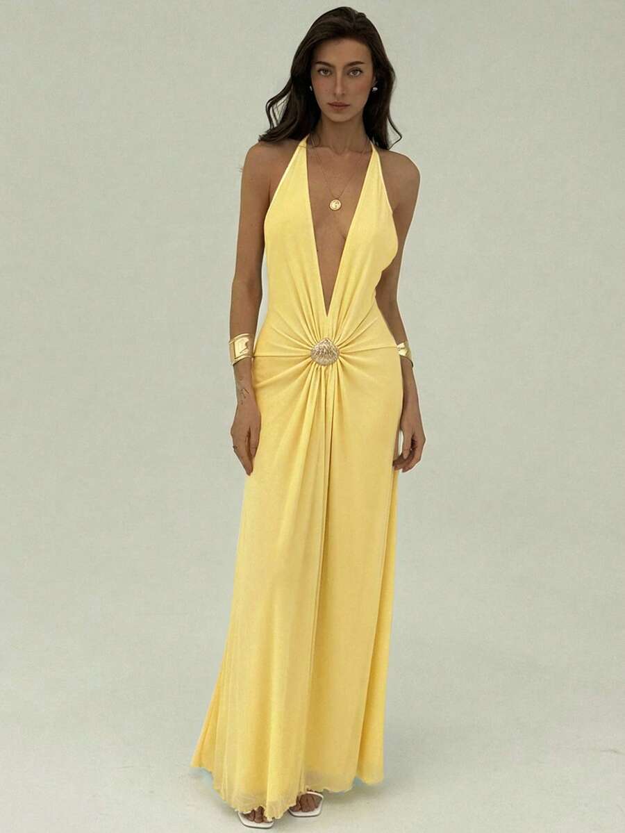 Front view of pale yellow halter maxi dress with metallic shell waist detail