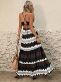 Back view of black and white halter maxi dress with crisscross tie-back detail