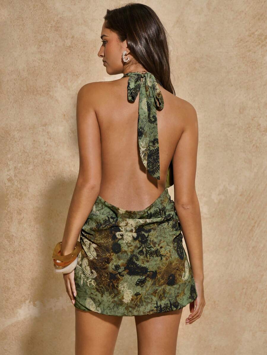 Embrace effortless elegance with this stunning floral print chiffon mini dress. Featuring a flattering halter neckline, backless design, and strategic side slit, this piece delivers a bold, sexy silhouette perfect for beach days and vacation adventures. The A-line cut with fitted bodice creates a flattering shape, while the all-over floral pattern adds vibrant charm. Crafted from lightweight woven polyester with a lined interior, it's comfortable and easy to care for. Sleeveless and mid-waist, this versatil