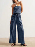 Front view of washed blue strapless wide-leg jumpsuit with drawstring waist and patch pockets