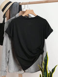 Back view of black short-sleeve T-shirt on hanger with side knot and clothing-rack styling
