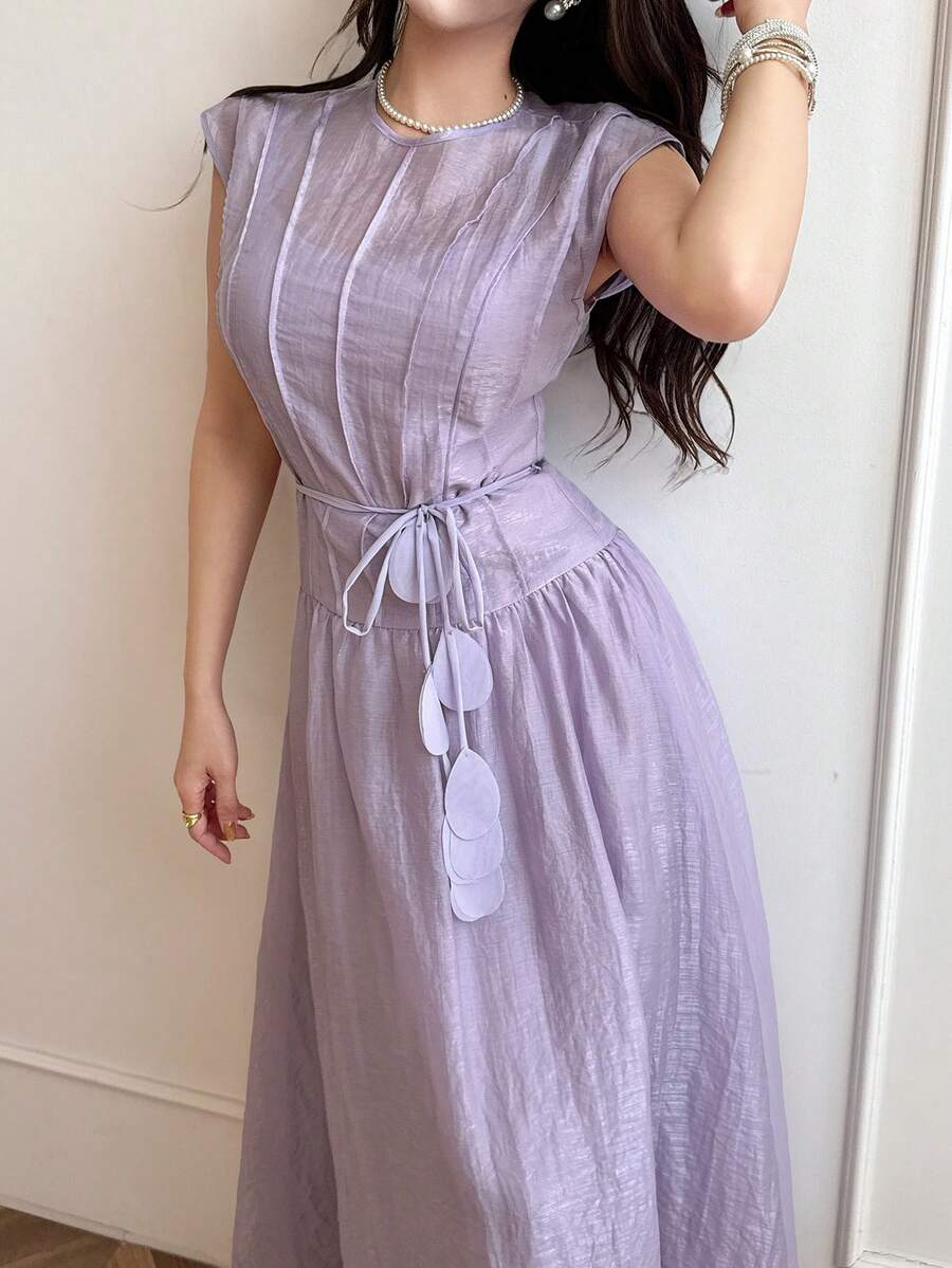 Front view of pale lilac belted A-line maxi dress in elegant interior