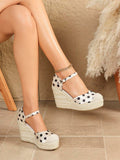 Three-quarter view of ivory polka-dot espadrille wedge sandals with rope platform soles