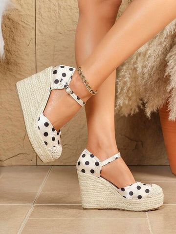 Side view of polka-dot closed-toe espadrille wedge sandals worn indoors with ankle buckle straps