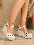 Front-side view of polka-dot closed-toe espadrille wedges with braided rope platforms