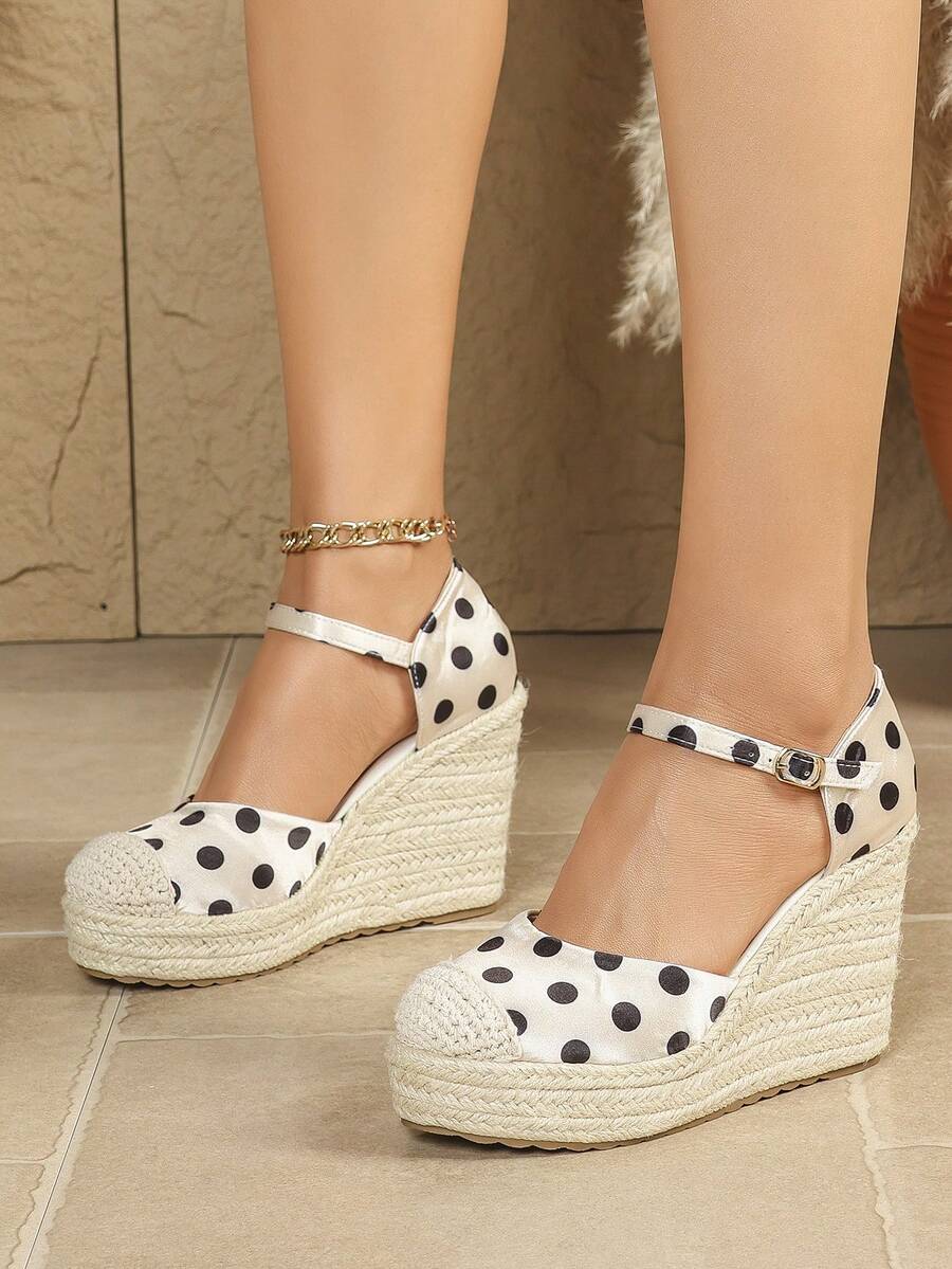 Front three-quarter view of ivory polka-dot espadrille wedge sandals with ankle straps
