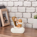 Front view of angel figurine holding a dog for home decor
