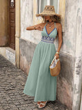 Front view of green boho halter maxi dress with geometric high waist and flared skirt