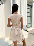 Rear full view of apricot embroidered mini party dress with flutter sleeves and waist bow