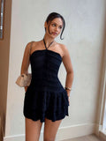 Side view of dark smocked halter mini dress showing ruffle layers and gathered waist