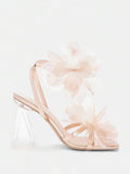 Studio side view of champagne floral high heel sandals with transparent heel