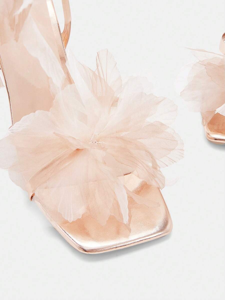 Top view of champagne metallic sandals with three-dimensional organza flower