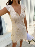 Close front view of champagne sequin party dress showing celestial embroidery and lined mesh