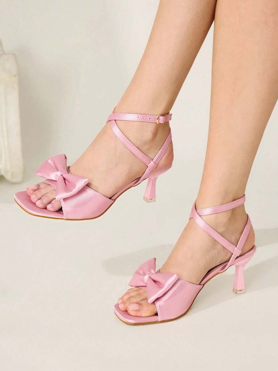 Elevate your special occasions with these stunning pink satin bow high heel sandals. Featuring a chic square toe design and secure ankle strap, these stiletto heels deliver effortless elegance for banquets, parties, and festive celebrations. The mid-heel height offers comfortable all-day wear, while the soft fabric upper and durable rubber sole ensure lasting quality. Perfect for Valentine's Day, New Year's Eve, or any event where you want to make a sophisticated statement. Slip into luxury and confidence w