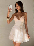 Back view of grey green floral embroidered spaghetti strap mini dress with low back