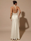 Woman wearing a white evening gown with a backless design on a beige background