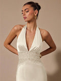 Woman wearing a white halter neck dress with a beige background