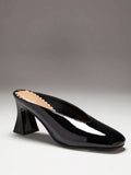Black side profile view of patent mule pumps with closed vamp, open back, softly squared toe, and flared block heel
