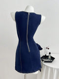 Back view of dark indigo denim mini dress with exposed zipper, contour seams, and waist tie