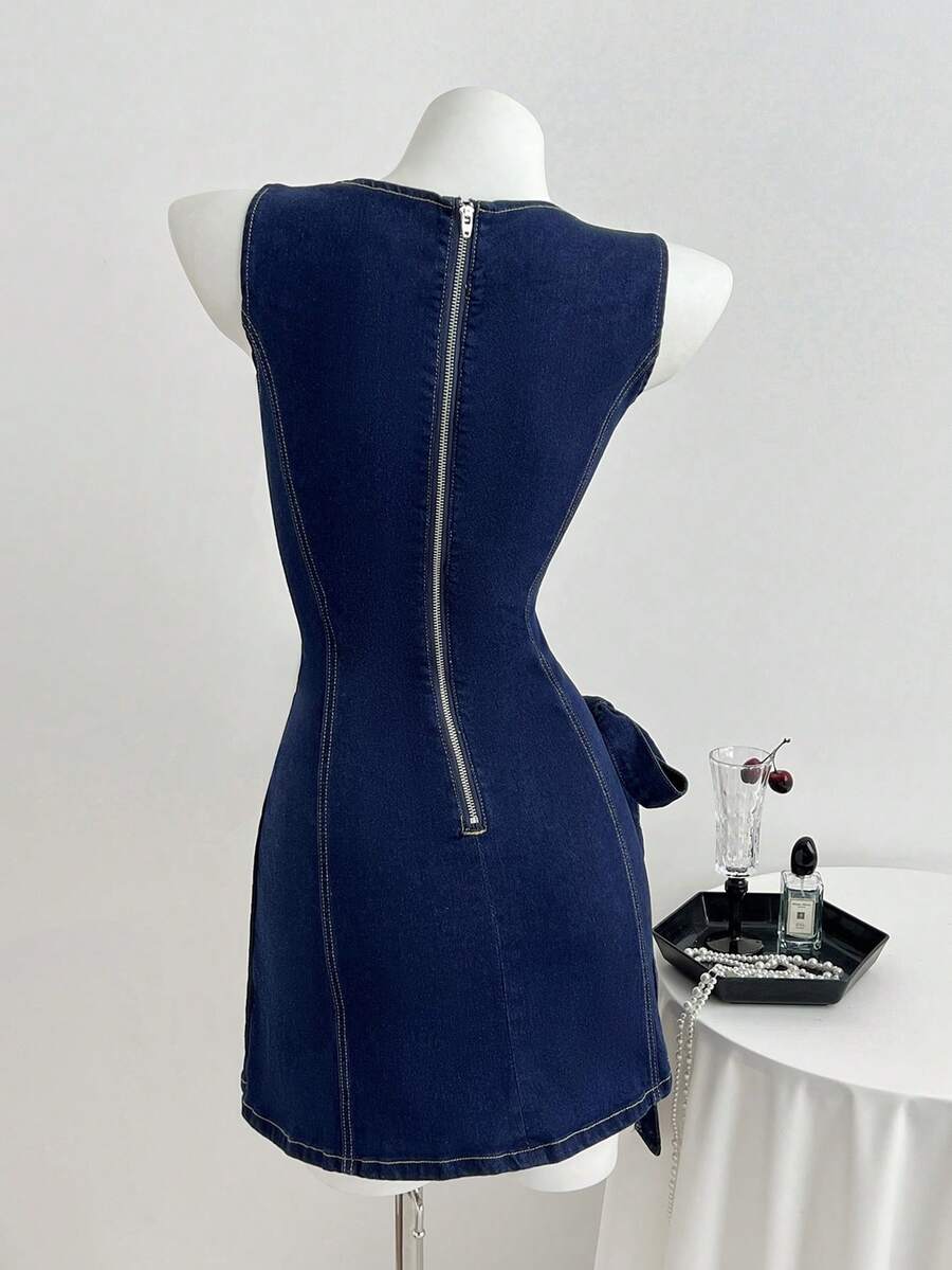 Back view of dark indigo denim mini dress with exposed zipper, contour seams, and waist tie