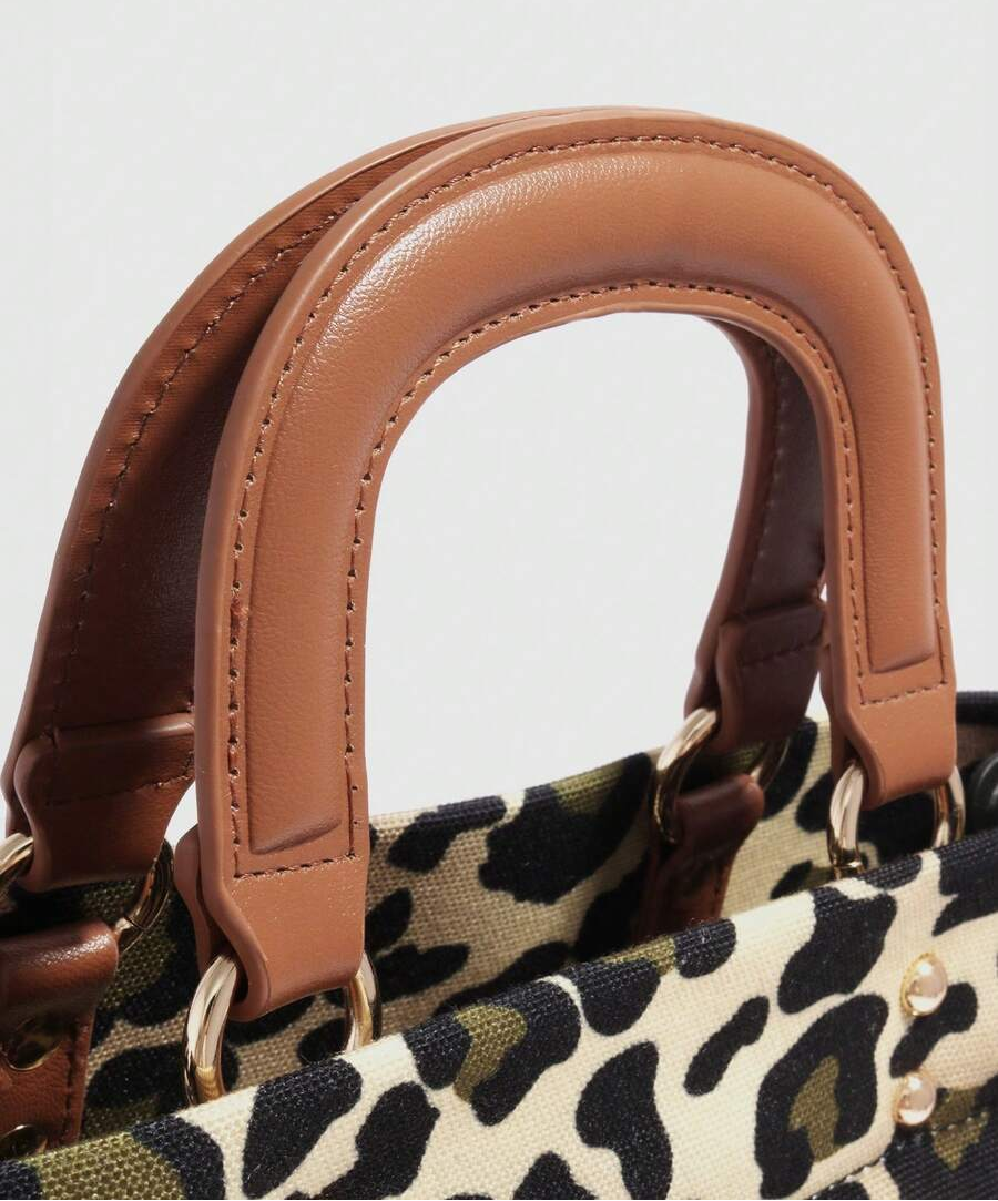 Close-up of brown stitched handbag handles with gold-tone rings above leopard-print fabric
