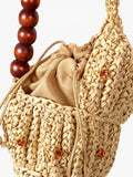 Close view of shell raffia bag showing crocheted texture and cord trim