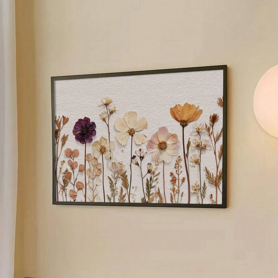 Hand-held view of vintage dried wildflower canvas art in a light wood display frame