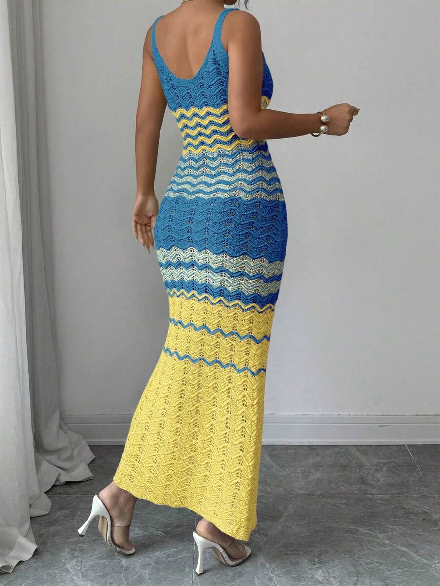 Back view of blue yellow and ivory crochet maxi dress with fitted shape and flared hem