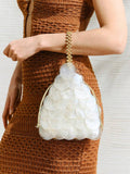 Neutral shell-disc drawstring bag showing scalloped paillettes and gold rope