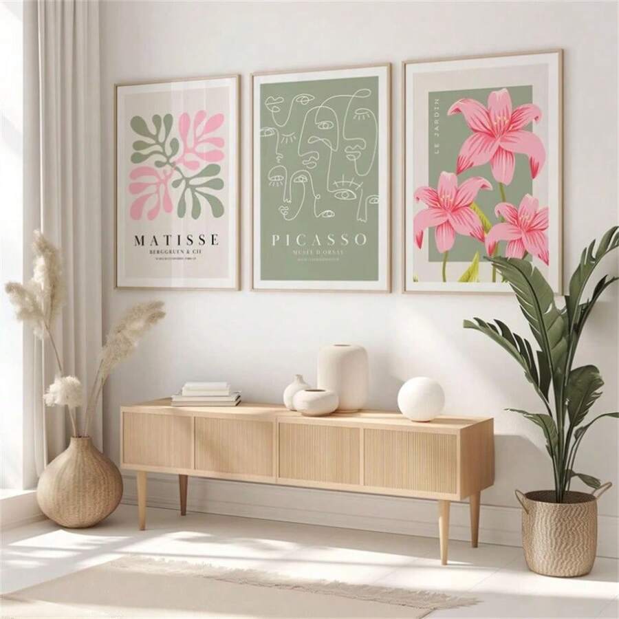 Three abstract Matisse-inspired botanical, Picasso-style line art and pink lily framed prints above a wood console