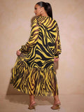 Rear view of yellow zebra print long dress with sheer sleeves and flowing lower tier