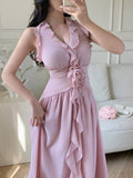 Close view of pale pink halter dress with ruffled V-neck and waist flower