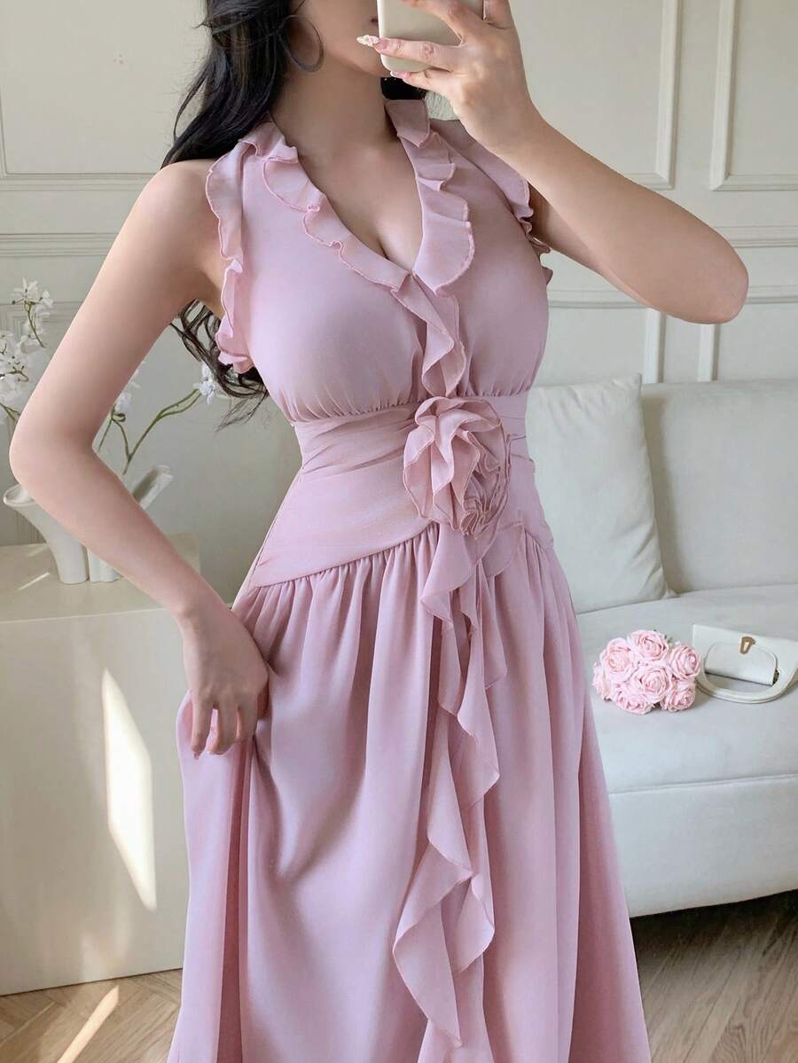 Close view of pale pink halter dress with ruffled V-neck and waist flower