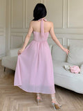 Back view of pale pink halter dress with tie neck and flowing A-line skirt