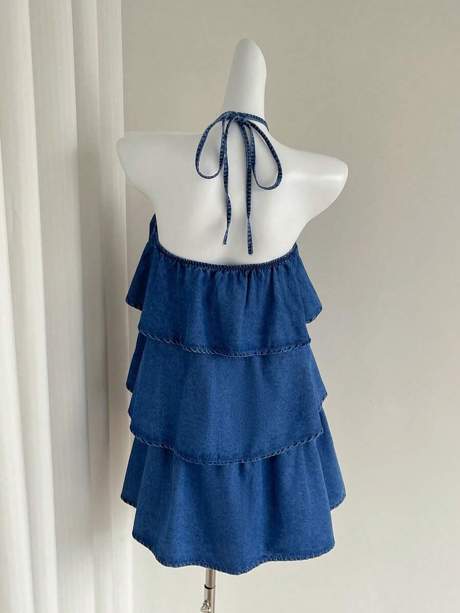 Front mannequin view of blue 3D rose halter denim mini dress with three flowing ruffle tiers