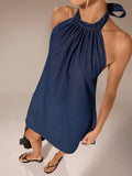 High-angle detail of gathered halter neckline and textured dark indigo denim mini dress