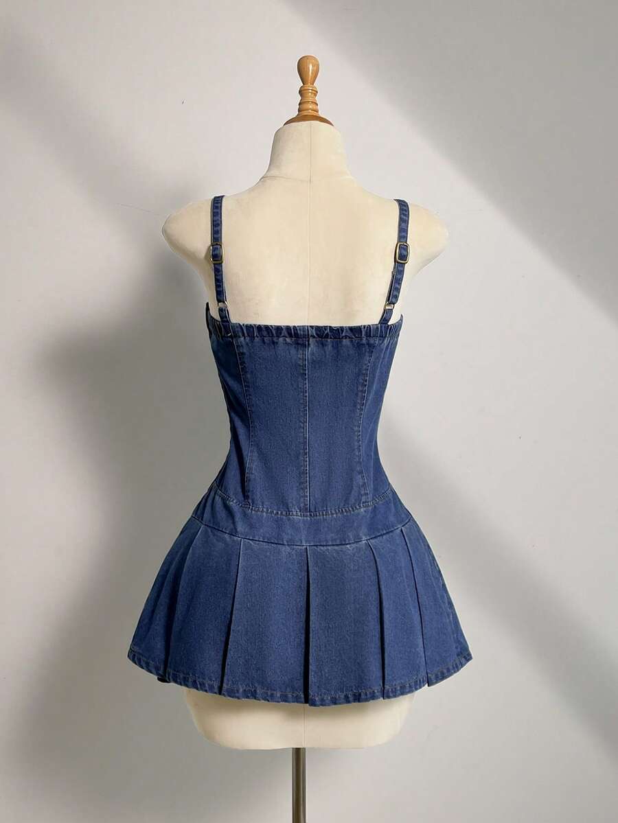Back view of blue denim mini dress showing adjustable straps and box pleats