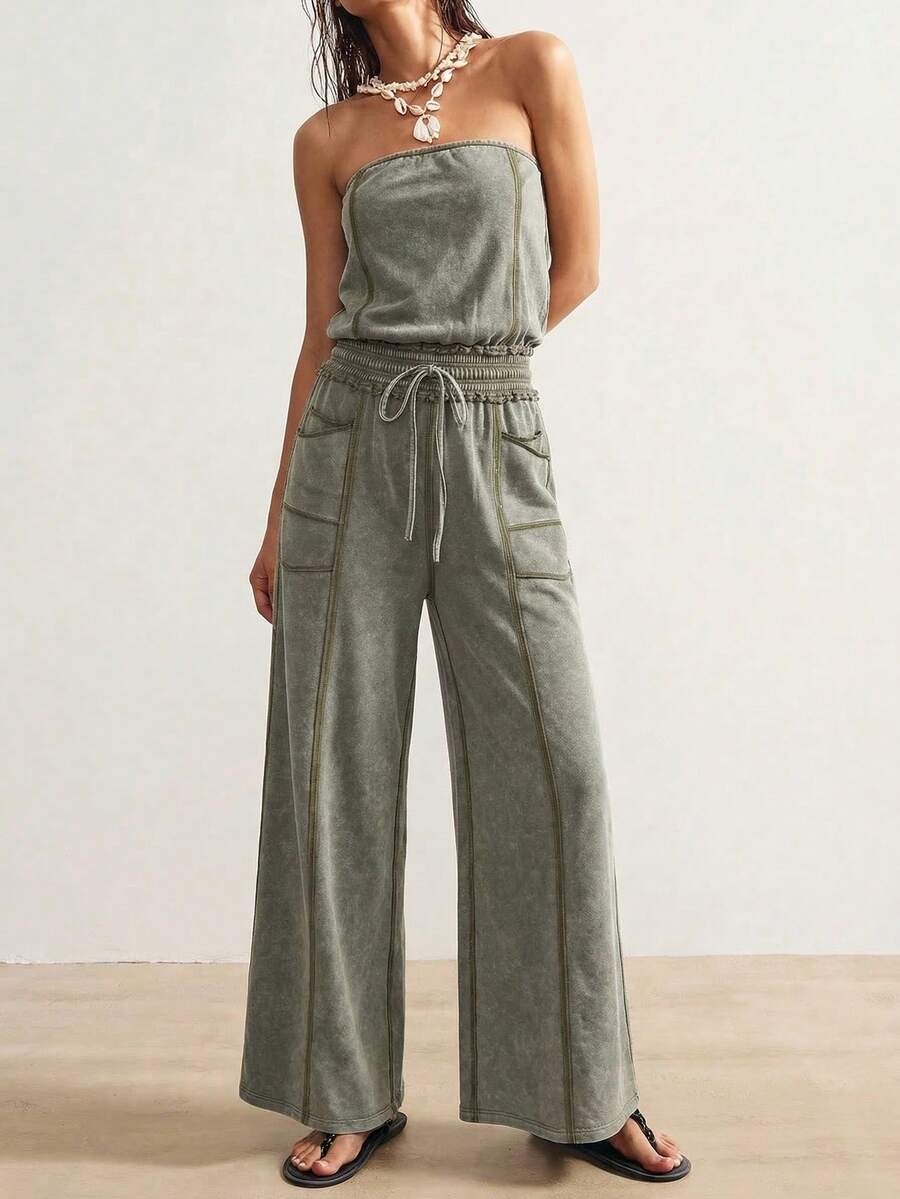 Front view of sage green strapless wide-leg jumpsuit with drawstring waist and utility pockets