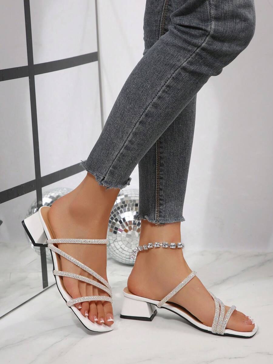 Side view of white square toe crystal mule sandals worn on foot
