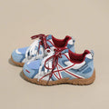 Rear-side view of light blue, white, and red lace-up sneaker with gum sole