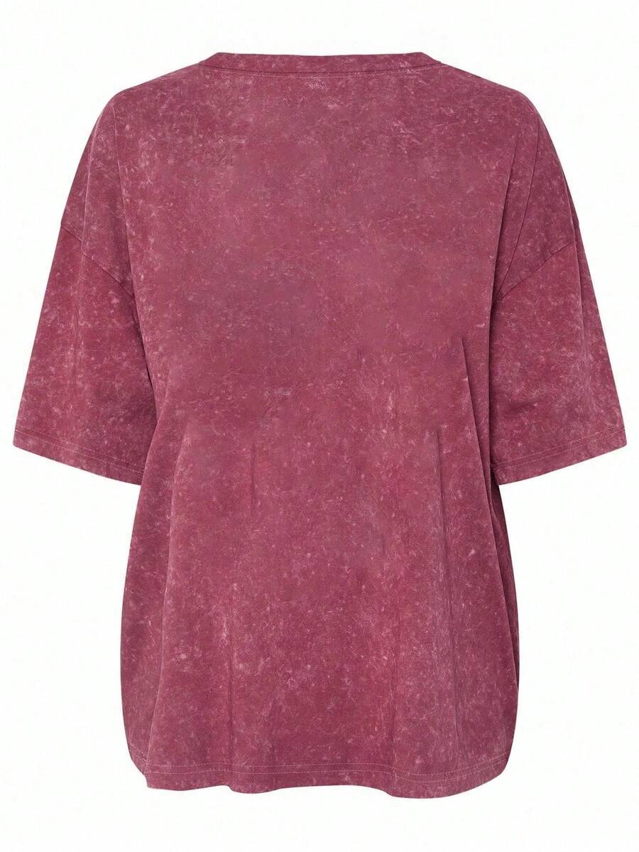 Front model view of burgundy acid wash plus size positive energy graphic tee with heart print