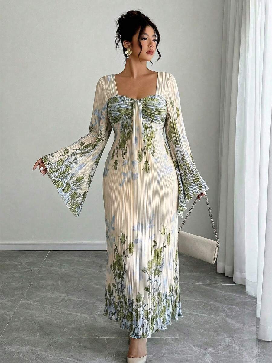 Front three-quarter view of ivory botanical pleated maxi dress with bell sleeves