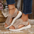 Front pair view of taupe open-toe wedge sandals worn with cropped jeans