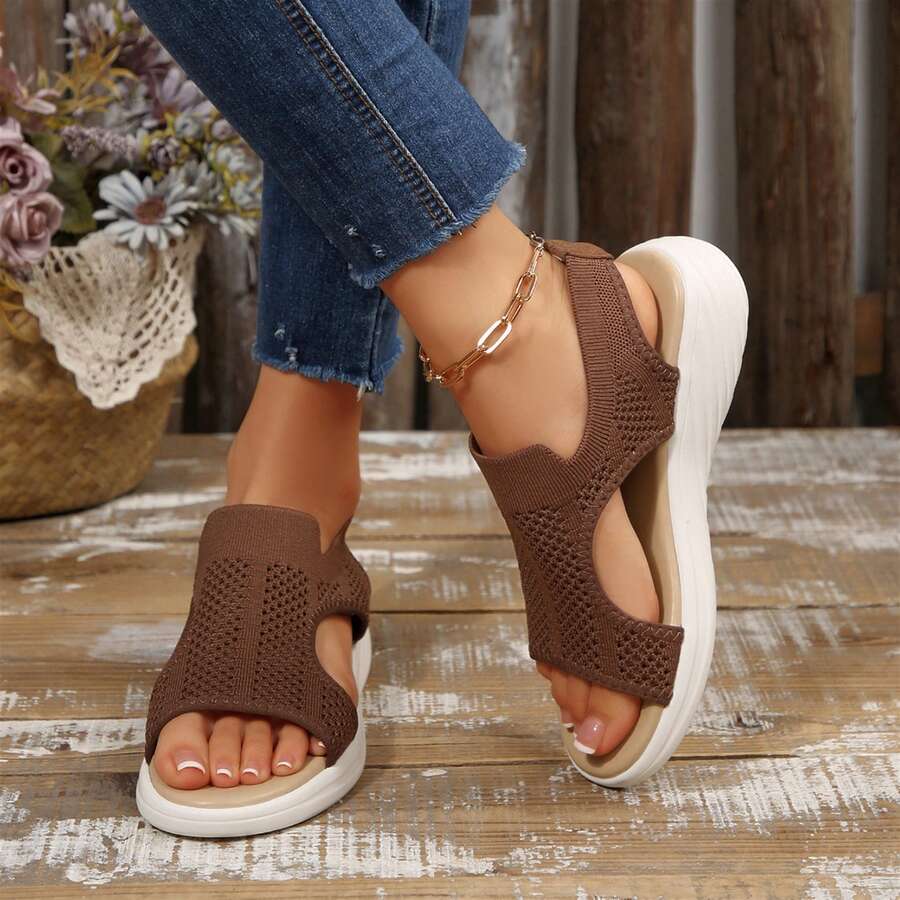 Front pair view of coffee brown open-toe sandals worn with cropped jeans