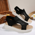 Three-quarter pair view of black open-toe mesh sandals with white wedge soles